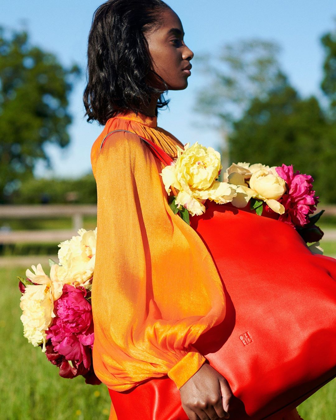 CAROLINA HERRERA - Blooming beautiful! The clementine orange cape mini dress from our Fall 2020 collection styled with the #CHMatryoshkaBag in red. Shot by @paul_maffi at @wesgordon’s farm in Connecti...