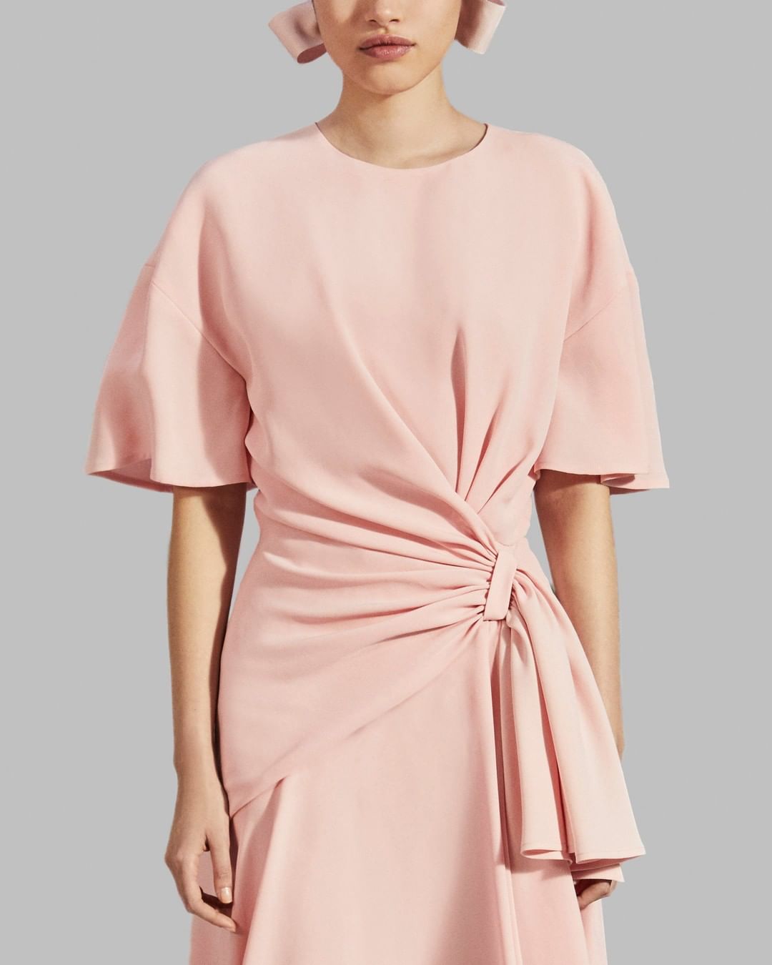 CAROLINA HERRERA - It's a cinch! This shell pink dress from the #prefall2020  collection by @wesgordon delivers effortless glamour with a simple yet striking side drape. 
#carolinaherrera