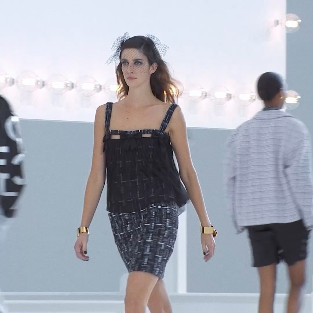 CHANEL - Fluttering black chiffon brings lightness to a tweed dress— the CHANEL Spring-Summer 2021 Ready-to-Wear collection, imagined by Virginie Viard and captured in motion at the Grand Palais in Pa...